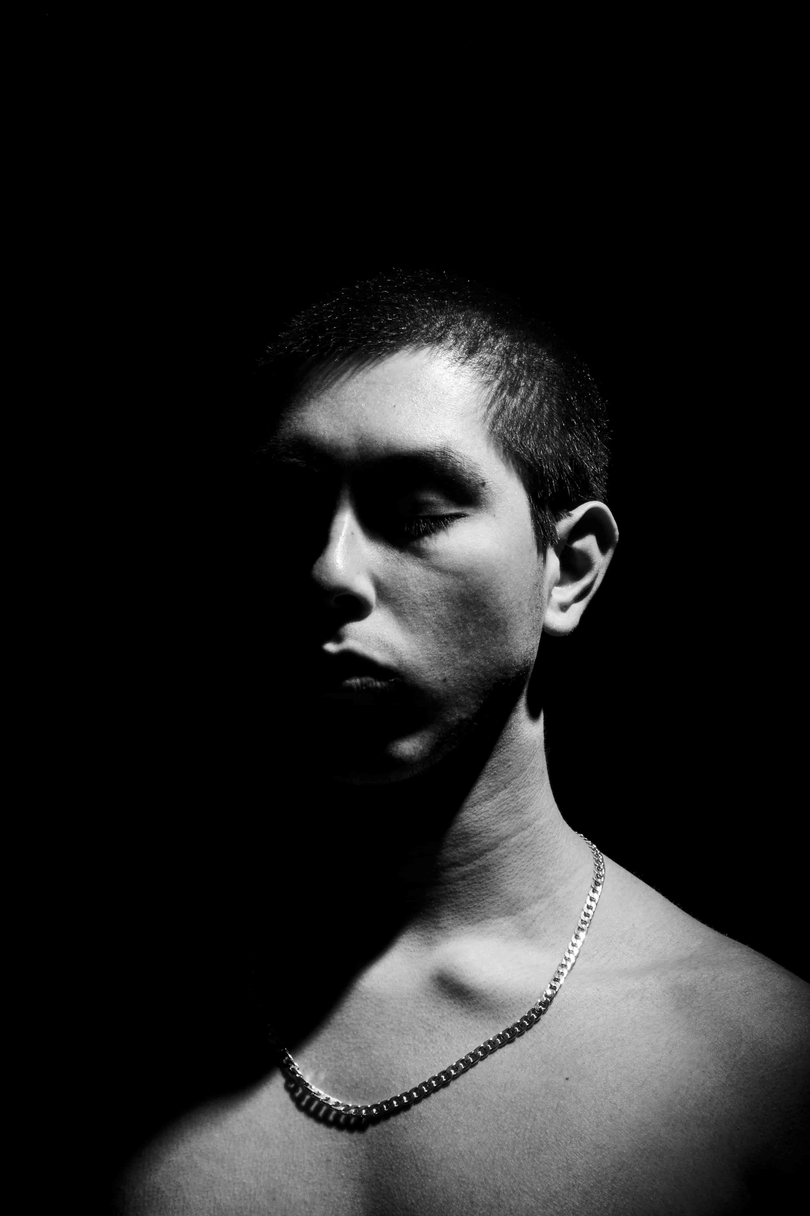 Fotografia del artista de pecho desnudo bañado en sobra