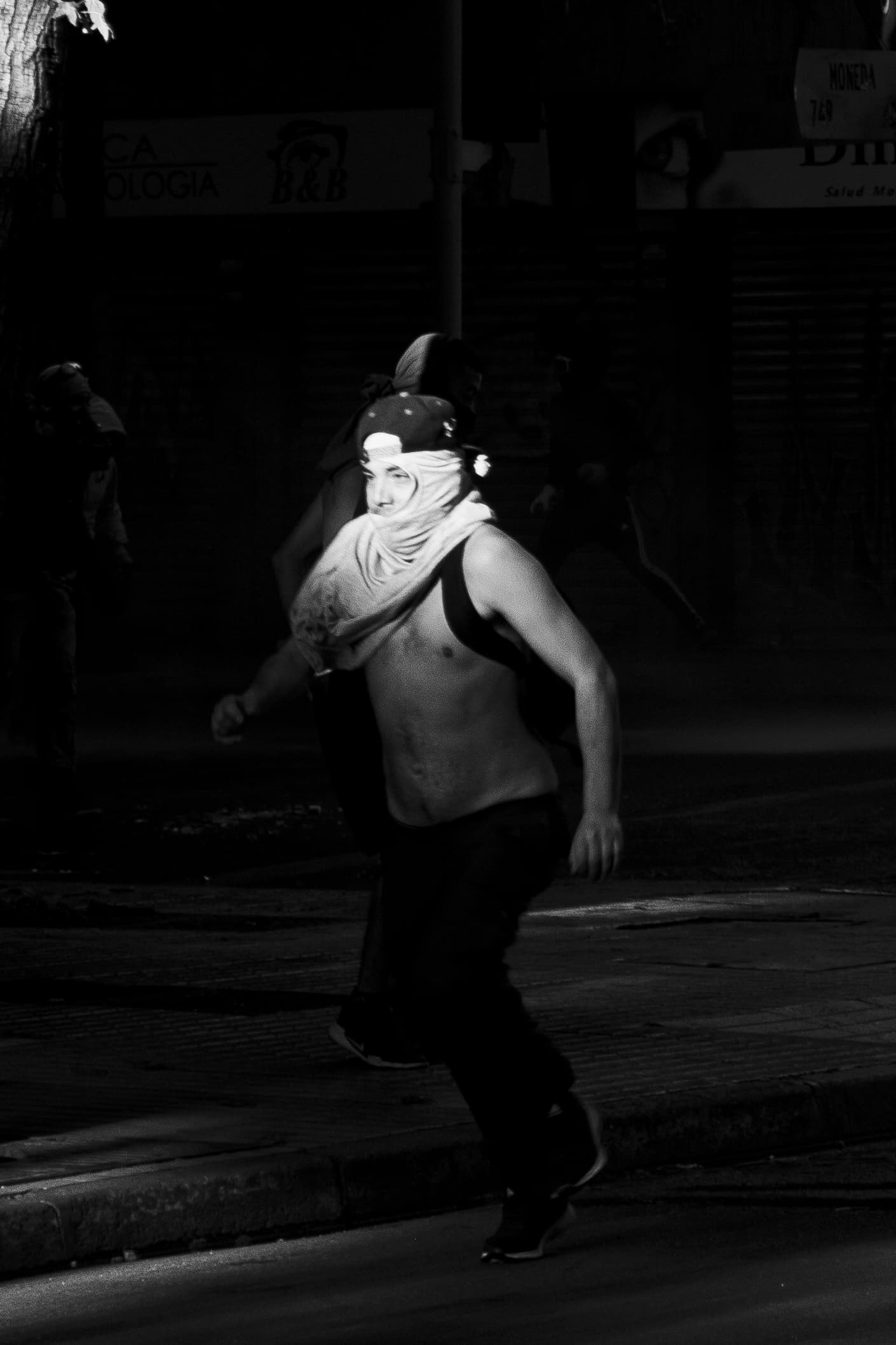 Fotografia de un joven con la cara tapada corriendo