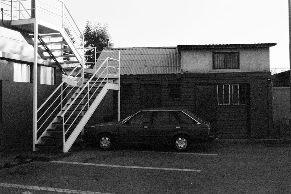Fotografia de un vehiculo estacionado bajo escaleras